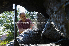 Les Bruning, owner of Bruning Sculpture in Omaha, uses a brush to remove dust and debris from Ruben 