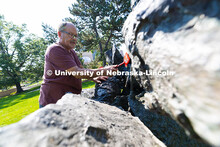 Les Bruning, owner of Bruning Sculpture in Omaha, uses a brush to remove dust and debris from Ruben 