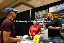 Dan Schmidt, a UNL alumni and parent of two UNL students, and Jen Jenkins chat with Matt Girard, a s