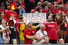 Fans hold up signs – a fire emoji, a cartoon bomb with a lit fuse that reads "ka boom," and a sign