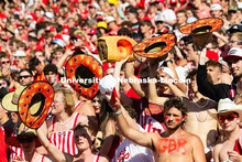Fans in the student section inadvertently form a line with their Runza hats as they cheer at the sta