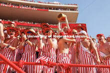 Fans dressed in striped overalls cheer after the Huskers scored a touchdown. Nebraska vs Michigan St