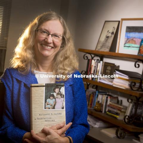 Margaret Jacobs holds her new book, A Generation Removed, which examines how government authorities in the post–World War II era removed thousands of American Indian children from their families and placed them in non-Indian foster or adoptive families. November 14, 2014. Photo by Craig Chandler / University Communications