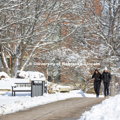 Students crossing campus to get to class. Michaela Dreeszen and Danielle Williams talk on the way to class. The UNL campus is covered by the first substantial snowfall of the year.  February 3, 2015. Photo by Craig Chandler / University Communications.