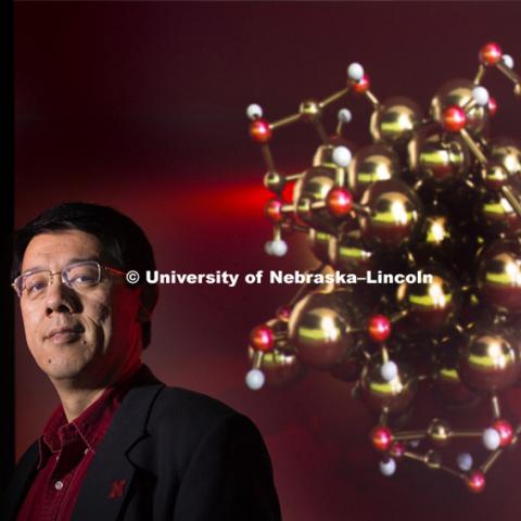 Xiao Zeng, Professor of Chemistry, Physics & Astronomy stands before a rendering of the gold nano particles. April 13, 2015. Photo by Craig Chandler / University Communications
