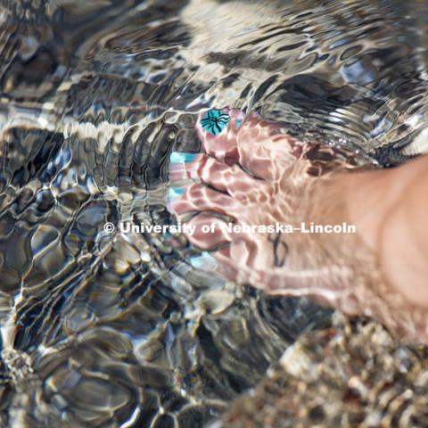 Taylor Pytleski relaxes with her feet in Broyhill Fountain on the first day of classes, August 24, 2015. Photo by Craig Chandler / University Communications