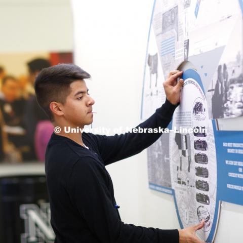 Eric Adame, freshman in architecture, hangs a class project in the Nebraska Union. January 24, 2017. Photo by Craig Chandler/University Communication.