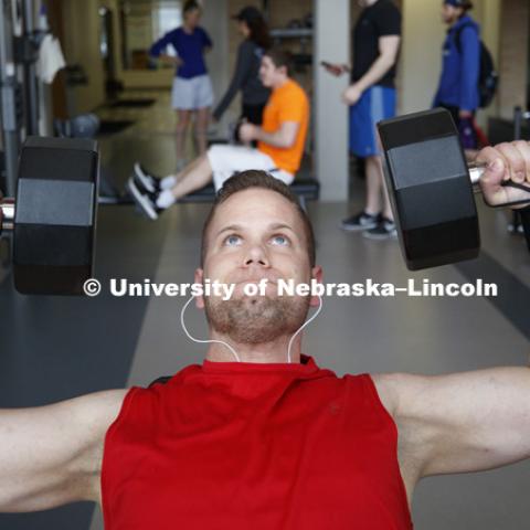 Grant Essint does shoulder presses in East Campus Recreation Center. March 6, 2017. Photo by Craig Chandler / University Communication.