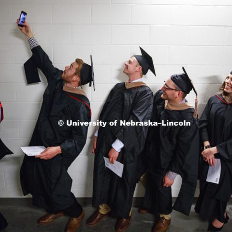 Tommie Bardsley takes a selfie before commencement with his fellow Masters Degree graduates in Business. Students earning graduate and professional degrees received their diplomas Friday afternoon in Lincoln's Pinnacle Bank Arena. Undergraduate