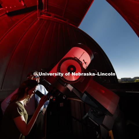 In the observatory atop the stadium parking garage, Hannah Paxton, senior in advertising and marketing, and Teaching Assistant for Professor Sibbernsen, eyes the skies under the supervision of Michael Sibbernsen, Lecturer of Astronomy- University of Nebraska-Lincoln, Special Projects Facilitator- NASA Nebraska Space Grant and NASA Solar System Ambassador. May 5, 2017. Photo by Craig Chandler / University Communication.