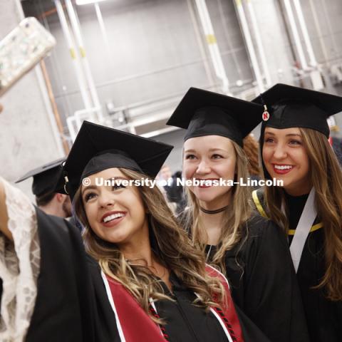 Taylor St. Peter, Avery Sass and Briley Moates take a selfie before commencement after lining up in the hallways off the arena floor. Students received their undergraduate diplomas Saturday morning in Lincoln's Pinnacle Bank Arena. 2452 degrees were