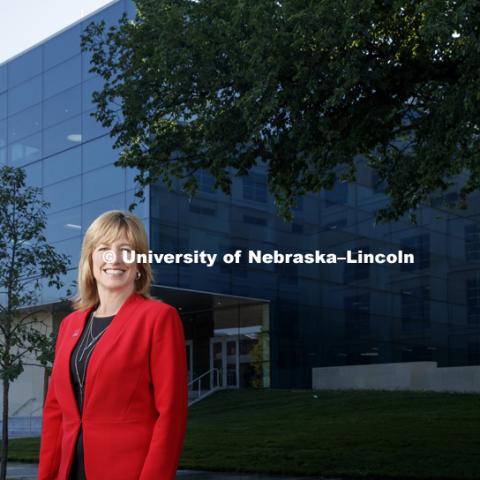 Kathy Farrell, interim Dean of the College of Business. She stands in front of the new building, Hawks Hall, opening in the fall. July 14, 2017. Photo by Craig Chandler / University Communication.