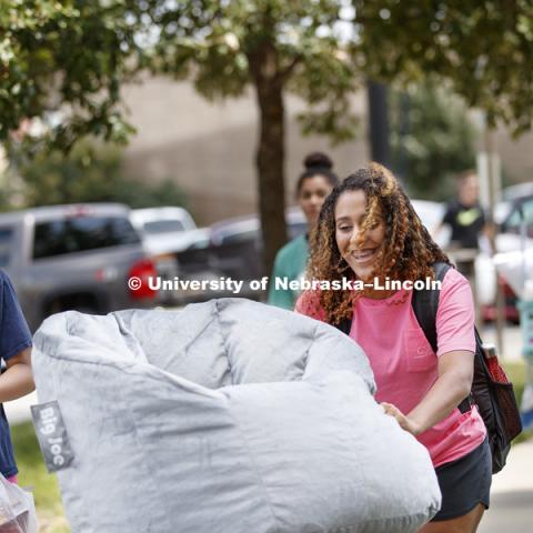 Noel Smith, right, of Omaha, pushes a cart full of belongings as she and her sister, Gianna, eye a precariously balanced beanbag chair. Sorority Rush move-in for residence halls. Housing. August 13, 2017. Photo by Craig Chandler / University Communication