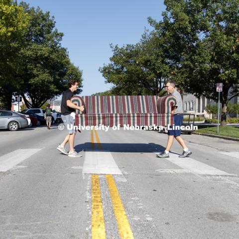 Luke Jarecke and his dad, Greg, carry a couch across R Street on their way to Beta Theta Pi fraternity. August 17, 2017. Photo by Craig Chandler / University Communication.