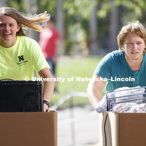 Transfer student William Roe and housing volunteer helper Brianna Smith push carts of Roe's belongings toward the new Massengale Residence Center. August 17, 2017. Photo by Craig Chandler / University Communication.