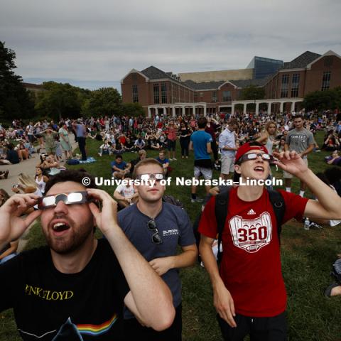 Sophomores Rob Hammack, Kevin Heckman and Mason Roe gazed up at 12:49 pm. Students gather on the green space between the Nebraska Union and the Raikes School to view the solar eclipse. August 21, 2017. Photo by Craig Chandler / University Communication.
