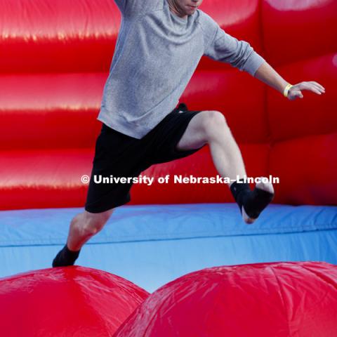 Students leap, jump and bounce in the Leaps and Bounds, an obstacle course comprised of three inflated balls in an inflatable pit. Back to School Bash on the Nebraska Union Plaza and Green Space sponsored by Campus NightLife. Students enjoyed a headphone
