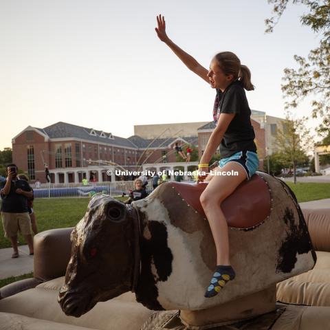 Holly Ecker gets an arm up as she rides the mechanical bull at the Back to School Bash on the Nebraska Union Plaza and Green Space sponsored by Campus NightLife. Students enjoyed a headphone disco party, inflatable games, and refreshments. August 25, 2017