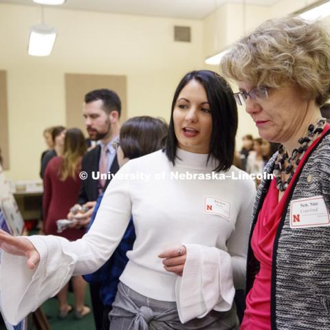 Senator Sue Crawford listens as Jayden Barth explains the effects of prior education on the success of inmates in prison education programs. State Senators Research Fair at the Capitol. April 10, 2018. Photo by Craig Chandler / University Communication.