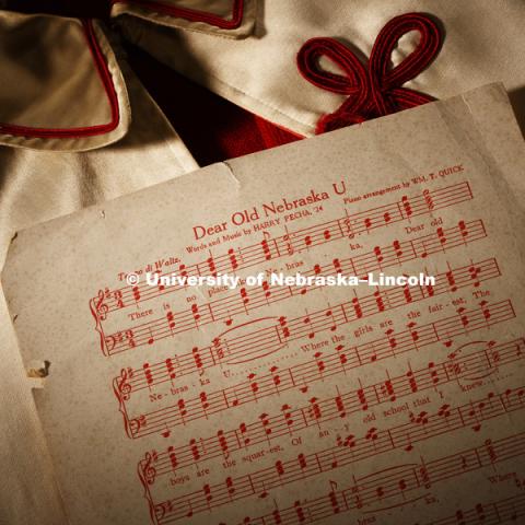 Dear Old Nebraska U sheet music lies on an old drum major cape which now resides in the Alumni Center. Photographed for the N150 anniversary book. May 24, 2018. Photo by Craig Chandler / University Communication.
