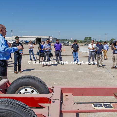 Ron Faller, left, and Bob Bielenberg, right, explain various test areas of the facility to the NASCAR tour group. Test of bull-nose barrier for use in medians to protect cars from overpass columns. Test was at university's Midwest Roadside Safety Facility at the Lincoln airport. June 5, 2018. Photo by Craig Chandler / University Communication.