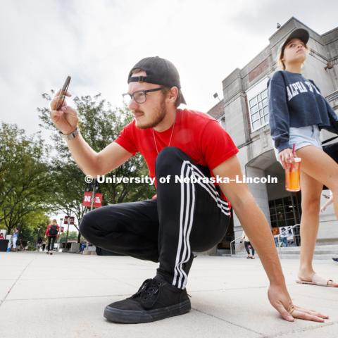 Mitchell Francis, a sophomore from Omaha, gets the angle for a photo of the Grit and Glory words in front of the fountain. In Our Grit, Our Glory brand reveal party on city campus at the Nebraska Union. August 30, 2018. Photo by Craig Chandler / University Communication.