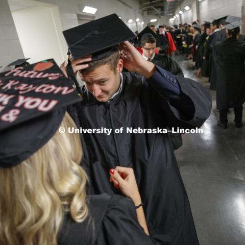Thomas Kayton and Lynsey Coufal adjust their mortarboards before commencement. The two graduates will marry in May. Undergraduate Commencement in Pinnacle Bank Arena. December, 15, 2018. Photo by Craig Chandler / University Communication.
