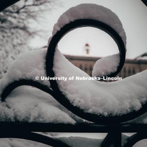 Curves in fence are covered in snow focus on the cupola of Love Library. January 12, 2019. Photo by Justin Mohling, University Communication.