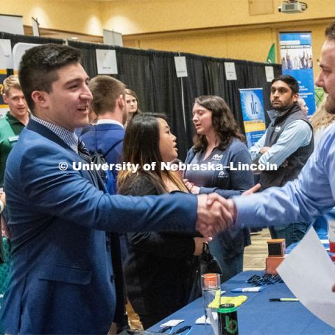 Oscar Chavez-Franco introduces himself with a recruiter from TEK systems at the STEM Career Fair (Science, Technology, Engineering, and Math) in Embassy Suites. Sponsored by Career Services. February 12, 2019. Photo by Gregory Nathan / University Communication.