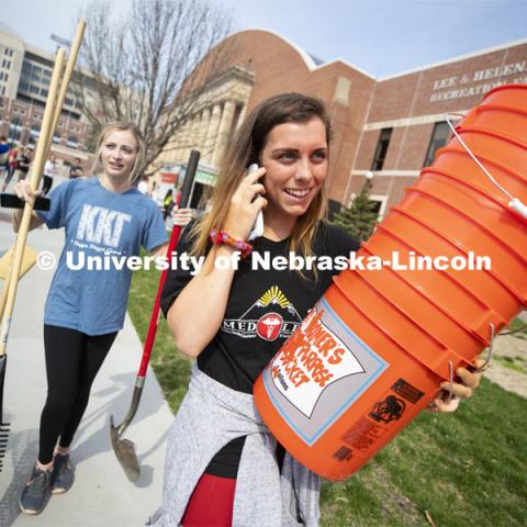 Brooklyn Housh calls her team as she and Kennedy Wolfe carry supplies from the Coliseum. More than 2,500 University of Nebraska–Lincoln students, faculty and staff volunteered for the Big Event on April 6, completing service projects across the community. Now in its 13th year at Nebraska, the Big Event has grown to be the university's single largest student-run community service project. April 6, 2019. Photo by Craig Chandler / University Communication.