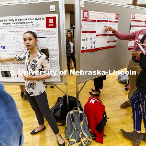 The Union ballroom becomes a hundred conversations at once including Lauren Lesiak, left, presenting her research while to the right is Kaleb Jones presenting his. Undergraduate Spring Research Fair in the Union ballrooms. April 15, 2019. Photo by Craig Chandler / University Communication.