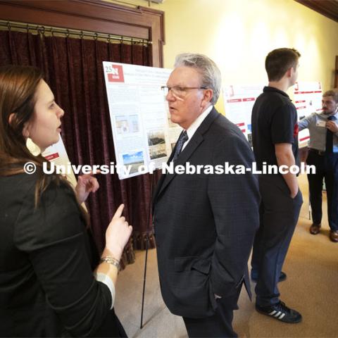 Michayla Goedeken of Madison explains her poster to Senator Jim Scheer of District 19. This year's research day at the capitol was held at the neighboring Ferguson House. Goedeken is researching the effects of dry-milling process on protein digestion of distillers grains in beef cattle. State Senators Research Fair at the Ferguson House. April 16, 2019. Photo by Craig Chandler / University Communication.