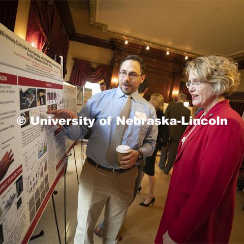 Chris Wiseman from Bellevue explains his poster to Senator Sue Crawford of the District 45. This year's research day at the capitol was held at the neighboring Ferguson House. Wiseman is researching “A wirelessly-controlled smart bandage with integrated miniaturized needle arrays for the treatment of chronic wounds.” State Senators Research Fair at the Ferguson House. April 16, 2019. Photo by Craig Chandler / University Communication.