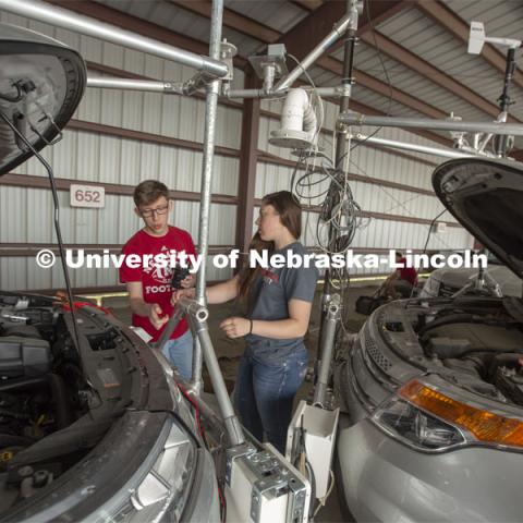 Nebraska students (from left) Brennan Darrah and Maddy Diedrichsen discuss how to attach instrumentation to the front of a mesonet (storm chase) vehicle during prep work for the TORUS project. April 26, 2019. Photo by Troy Fedderson / University Communication