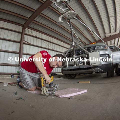 Graduate student Alex Erwin drills a pipe that will hold an instrument cluster on Nebraska's newest storm chase vehicle. Starting this spring, 13 Huskers will be part of TORUS, a national study designed to collect data about how severe storms and tornadoes are formed. April 26, 2019. Photo by Troy Fedderson / University Communication