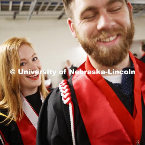 Students decked out in their graduation garb smile for the camera. Undergraduate commencement at Pinnacle Bank Arena, May 4, 2019. Photo by Craig Chandler / University Communication.