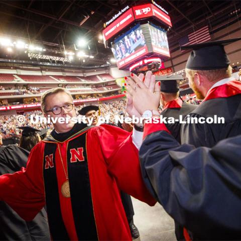 Chancellor Ronnie Green high fives graduates as they progress into the arena. Undergraduate commencement at Pinnacle Bank Arena, May 4, 2019. Photo by Craig Chandler / University Communication.