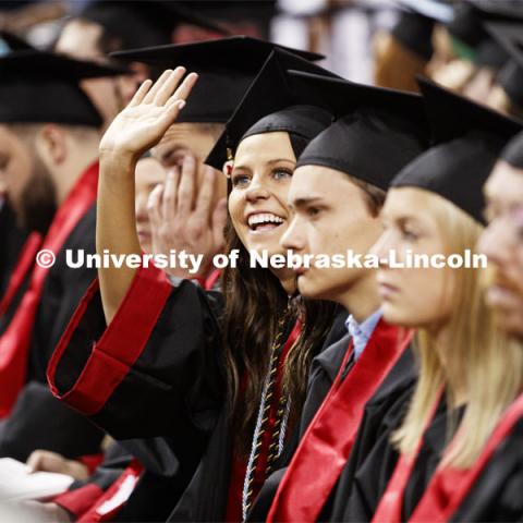 A young woman waves to her family. Undergraduate commencement at Pinnacle Bank Arena, May 4, 2019. Photo by Craig Chandler / University Communication.