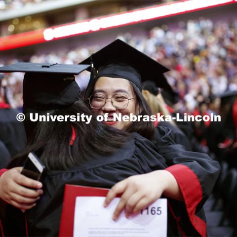 Yutong Mao exchanges greetings with fellow graduates as part of Regent Tim Clare's greeting. Undergraduate commencement at Pinnacle Bank Arena, May 4, 2019.  Photo by Craig Chandler / University Communication.