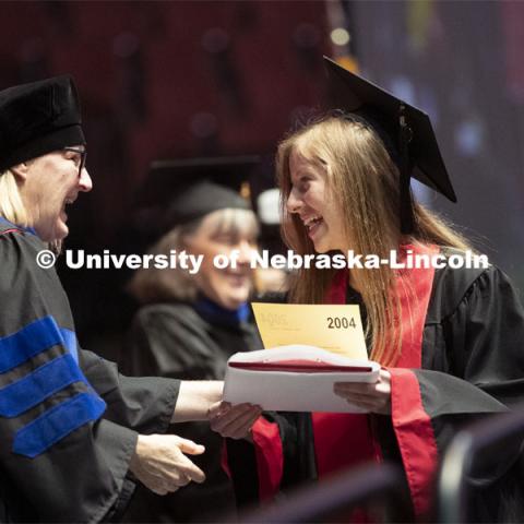 Lindsey Amen accepts her college of journalism diploma. Undergraduate commencement at Pinnacle Bank Arena, May 4, 2019. Photo by Craig Chandler / University Communication.