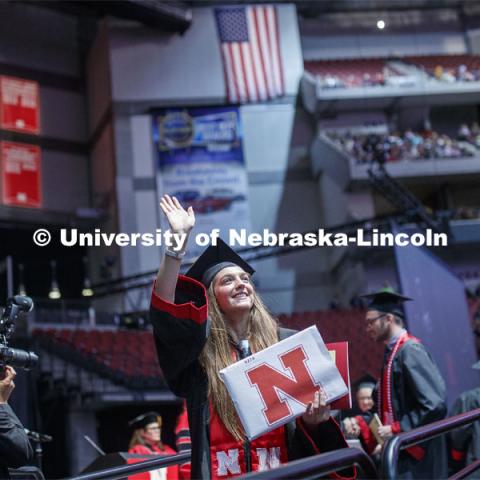 Marit Koszewski waves to family and friends after receiving her Arts and Sciences degree. Undergraduate commencement at Pinnacle Bank Arena, May 4, 2019. Photo by Craig Chandler / University Communication.