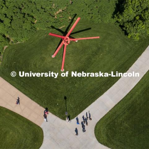 Students crossing campus near the Old Glory sculpture on City Campus. June 7, 2019.  Photo by Craig Chandler / University Communication.