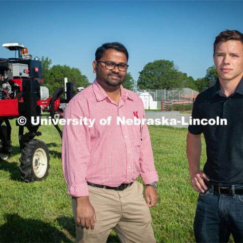 Grad student Josh Murman is with Santosh Pitla, associate professor of advanced machinery systems in the Department of Biological Systems Engineering at the University of Nebraska–Lincoln. Pitla is currently developing an autonomous tractor using ground robotics. Pitla and his team are testing their driverless tractor on the tractor testing field on East Campus. The autonomous tractors are named Flexible Structured Robotic Vehicle (FlexRo), the tractor is currently used for plant phenotyping, which is measuring the physical characteristics of the plant. According to Pitla, cameras are added to the machine to collect images that characterize plant conditions. Photo for the 2019 publication of the Strategic Discussions for Nebraska magazine. June 10, 2019, Photo by Gregory Nathan / University Communication. 