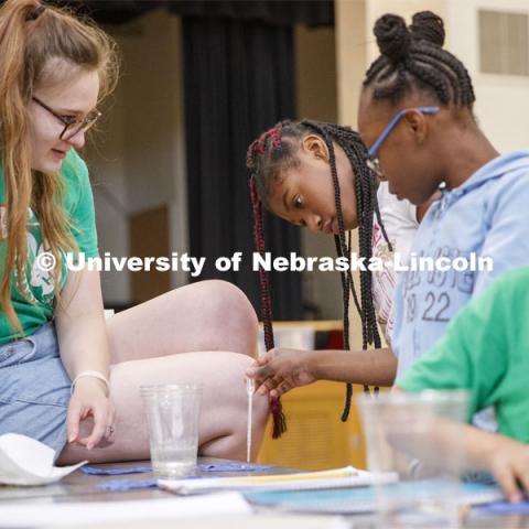 Elizabeth Brison, a UNO sophomore working with Extension this summer, watches as students place droplets of water on fabric samples. Elementary-age students in Omaha's Kennedy Elementary learned about nano technology and water Wednesday afternoon. STEMentors is helping put on summer camps with Imagine Science. June 19, 2019. Photo by Craig Chandler / University Communication.