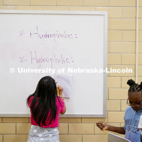 Students write down the science terms they are learning about so they can write their reports. Elementary-age students in Omaha's Kennedy Elementary learned about nano technology and water Wednesday afternoon. STEMentors is helping put on summer camps with Imagine Science. June 19, 2019. Photo by Craig Chandler / University Communication.