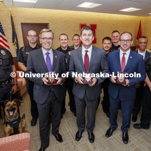 Chancellor Ronnie Green, President Hank Bounds and vice chancellor for Business and Finance Bill Nunez are surrounded by UNL Police Department members after the three were presented commemorative N150 Police Badges. June 20, 2019. Photo by Craig Chandler / University Communication.