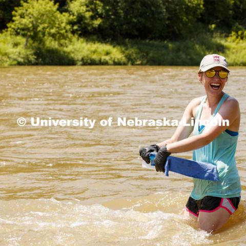 Kayla Vondracek, junior in Environmental Studies, laughs with her professor while collecting samples in the Niobrara River. Jessica Corman, assistant professor in the School of Natural Resources, UCARE research group researching algae in the Niobrara River. Fort Niobrara National Wildlife Refuge. July 12, 2019. Photo by Craig Chandler / University Communication.