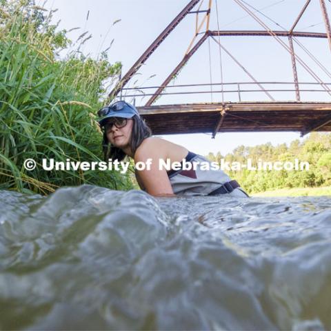 Sydney Kimnach, sophomore in environmental studies and fisheries and wildlife management, fixes her research project to the bank of the Niobrara. She places a collection of filter plates each saturated with elements, such as potassium, to see if the algae are attracted to various nutrients.  Her multiple sites also allow her to research if algae in different areas of the river seek out different nutrients. Jessica Corman, assistant professor in the School of Natural Resources, UCARE research group researching algae in the Niobrara River. Fort Niobrara National Wildlife Refuge. July 12, 2019. Photo by Craig Chandler / University Communication.