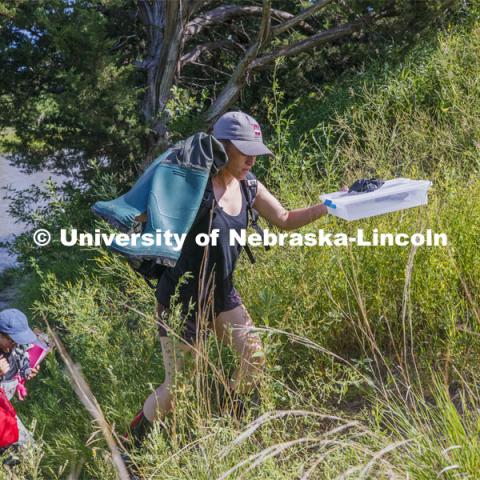 Kayla Vondracek and Sydney Kimnach work their way back from the Niobrara River after sampling a site. Jessica Corman, assistant professor in the School of Natural Resources, UCARE research group researching algae in the Niobrara River. Fort Niobrara National Wildlife Refuge. July 13, 2019. Photo by Craig Chandler / University Communication.