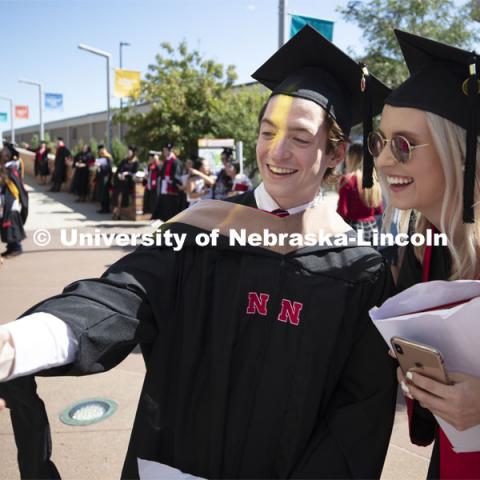 Benjamin Smith and Madison Roan take a selfie following commencement. 2019 Summer Commencement at Pinnacle Bank Arena. August 17, 2019. Photo by Craig Chandler / University Communication.